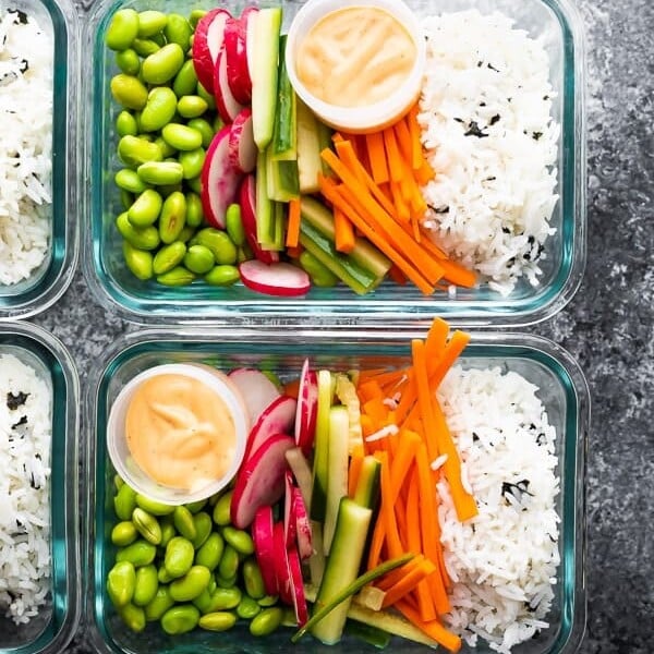 overhead shot of glass meal prep containers filled with vegan sushi bowls