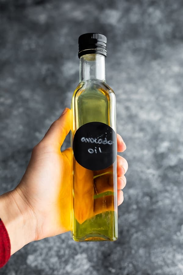 hand holding bottle of avocado oil