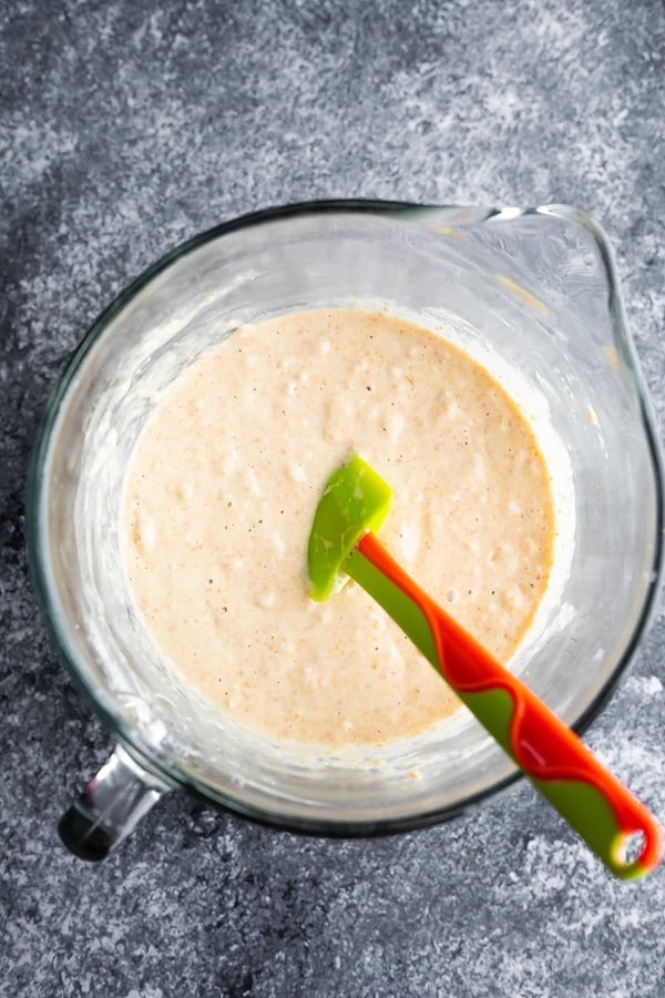 mixing pancake batter from overhead in glass measuring bowl with spatula
