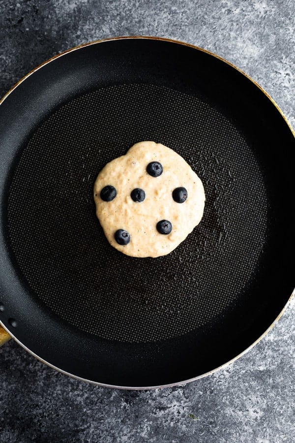 showing how to make blueberry pancakes in nonstick skillet
