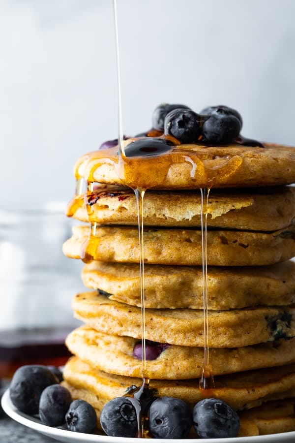 stack of blueberry pancakes with syrup drizzling