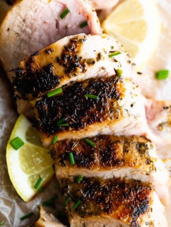 Close up shot of sliced pork tenderloin with fresh lemon slice