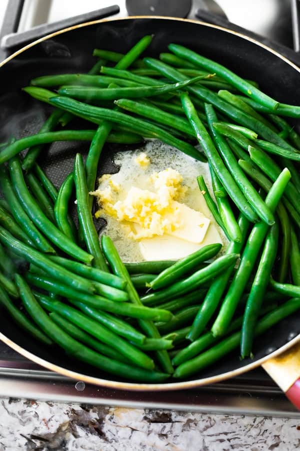 showing sauteed fresh green beans in pan with butter and garlic