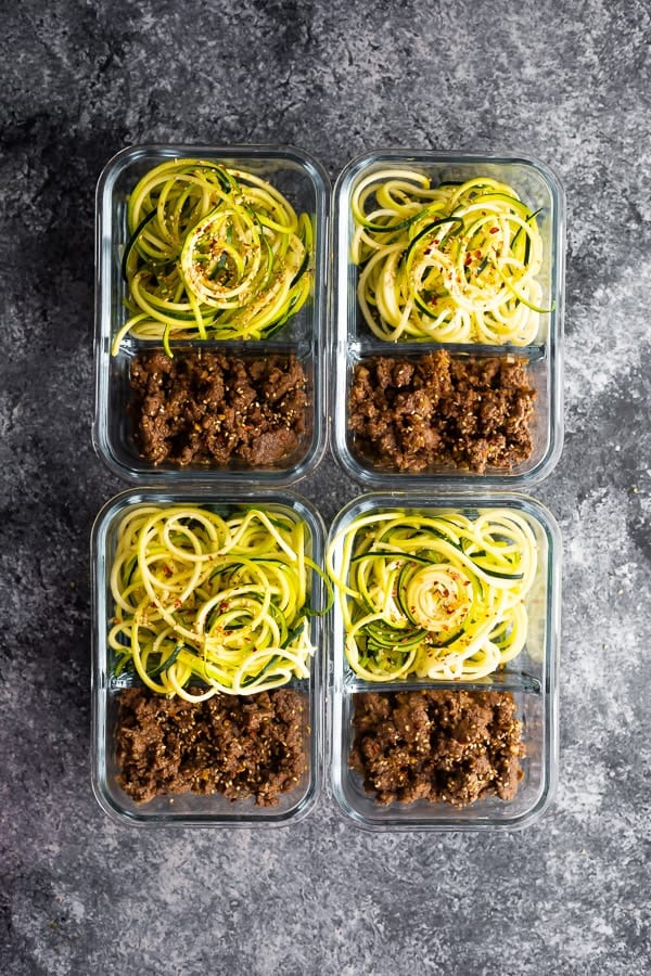 sesame ginger beef with zucchini noodles in 4 glass meal prep containers, overhead view