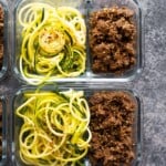 overhead shot of glass meal prep containers filled with sesame ginger beef and zucchini noodles