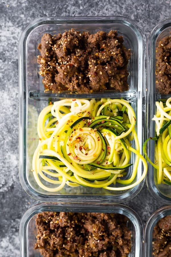 Sesame Ginger Beef and Zucchini Noodles in glass meal prep container, overhead view