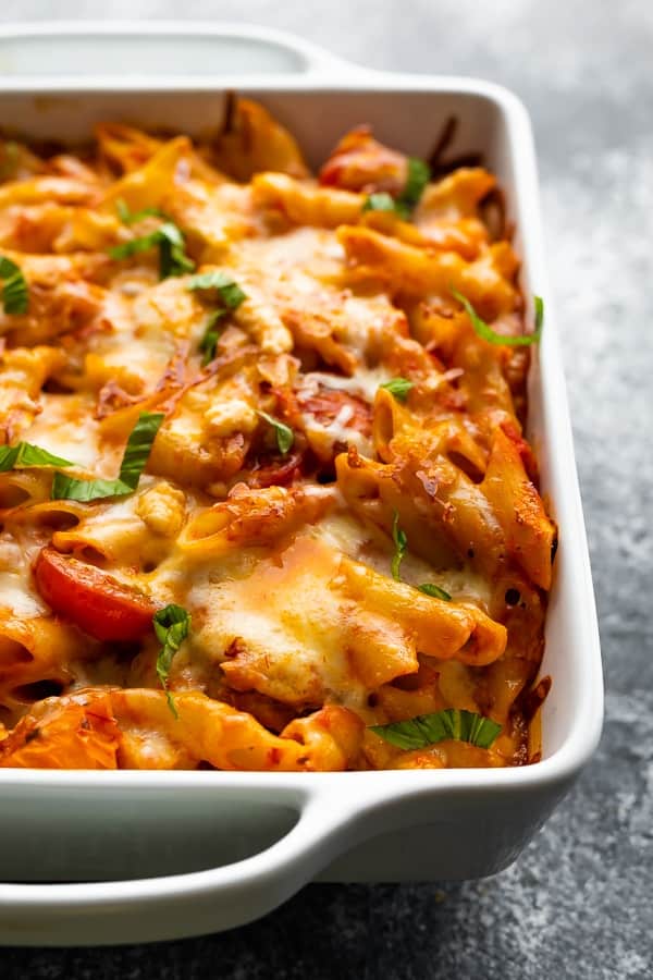 chicken caprese pasta in white baking dish