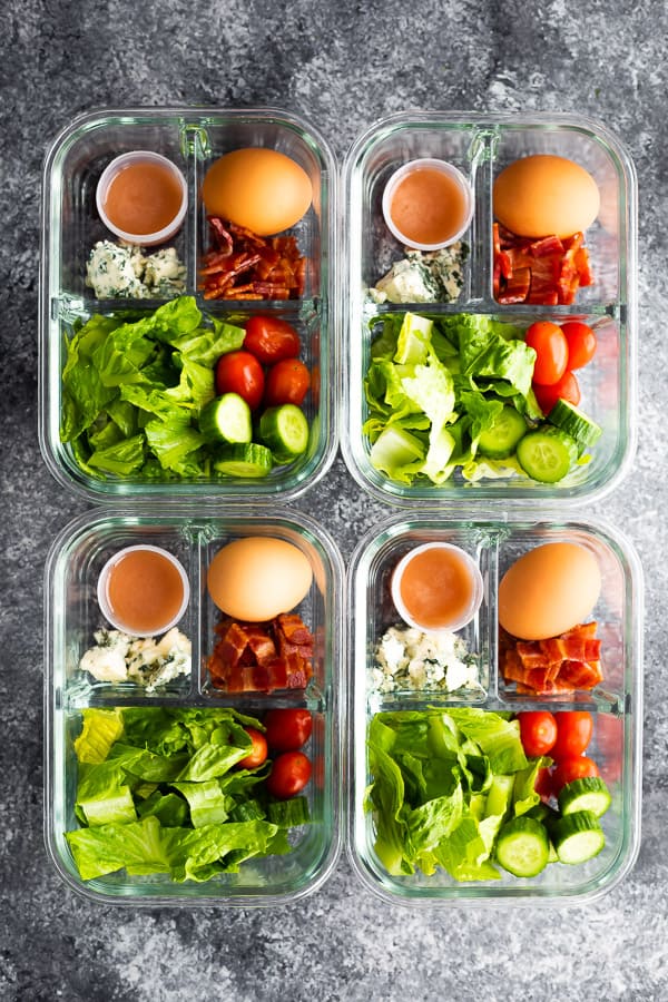 cobb salad recipe portioned out into four glass meal prep containers from overhead