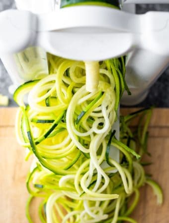 overhead shot of zucchini noodles coming out of spiralizer