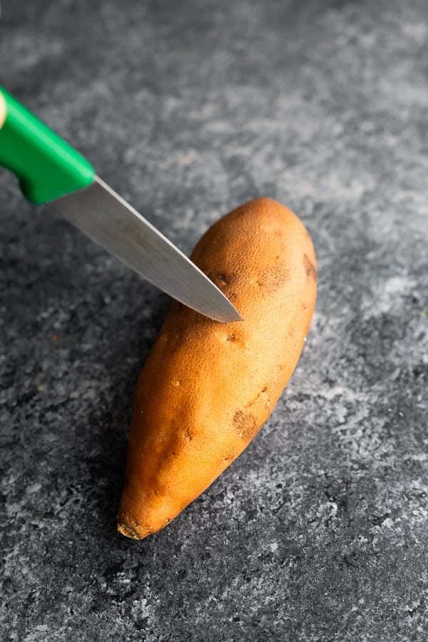 poking sweet potato before showing how to microwave a sweet potato
