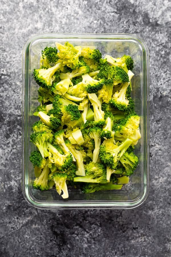 overhead shot of broccoli pieces in glass meal prep container