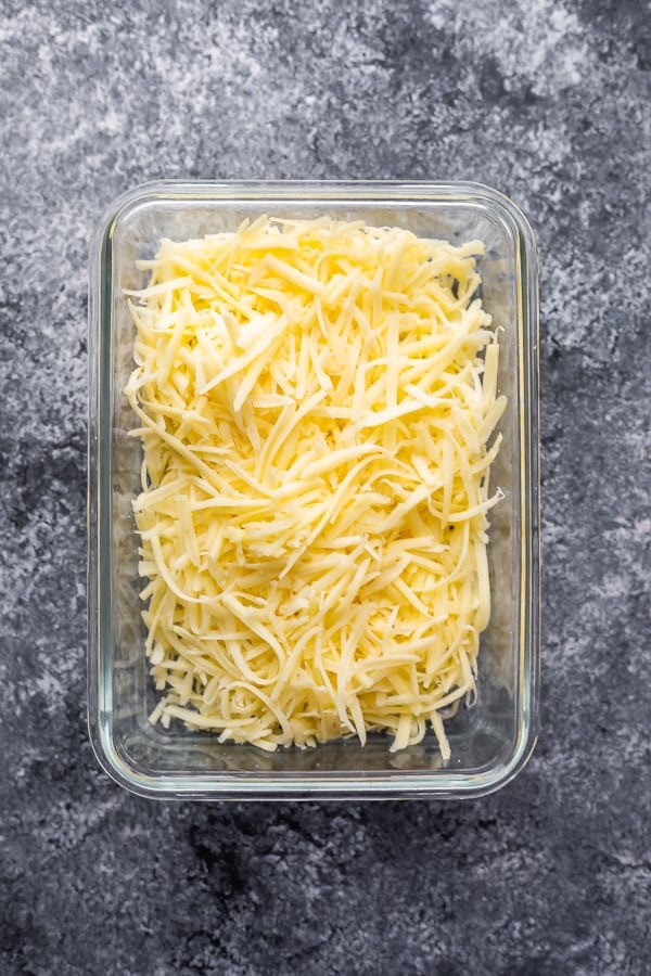 overhead shot of shredded cheese in glass meal prep container
