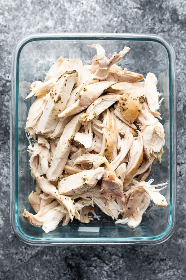 overhead shot of shredded chicken in a glass meal prep container