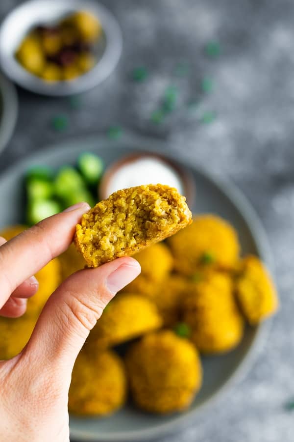 hand holding baked falafel recipe after taking a bite