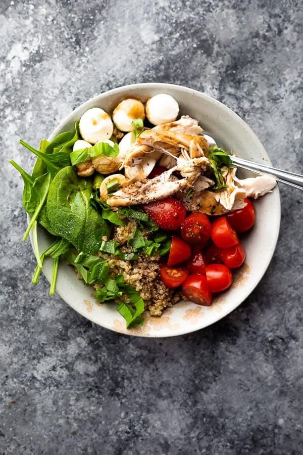 Overhead shot of caprese chicken quinoa salad on gray background