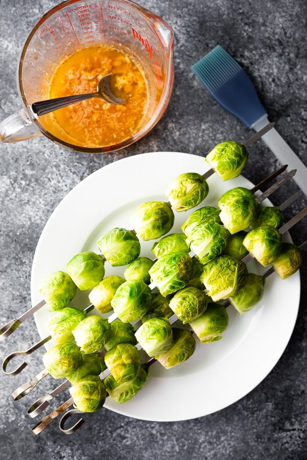 overhead view of grilled brussel sprouts recipe on skewers with garlic butter