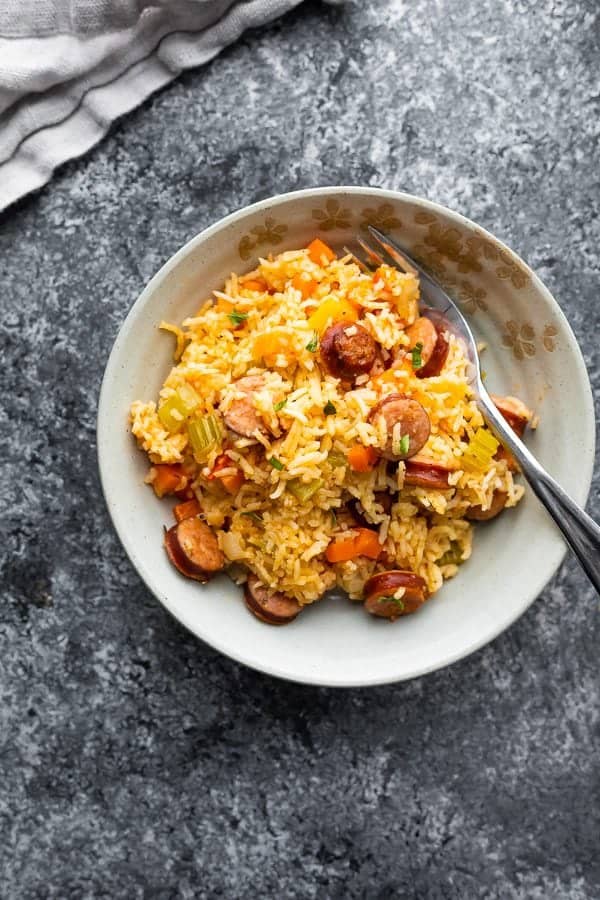 Overhead shot of cajun rice and sausage in a white bowl with a fork