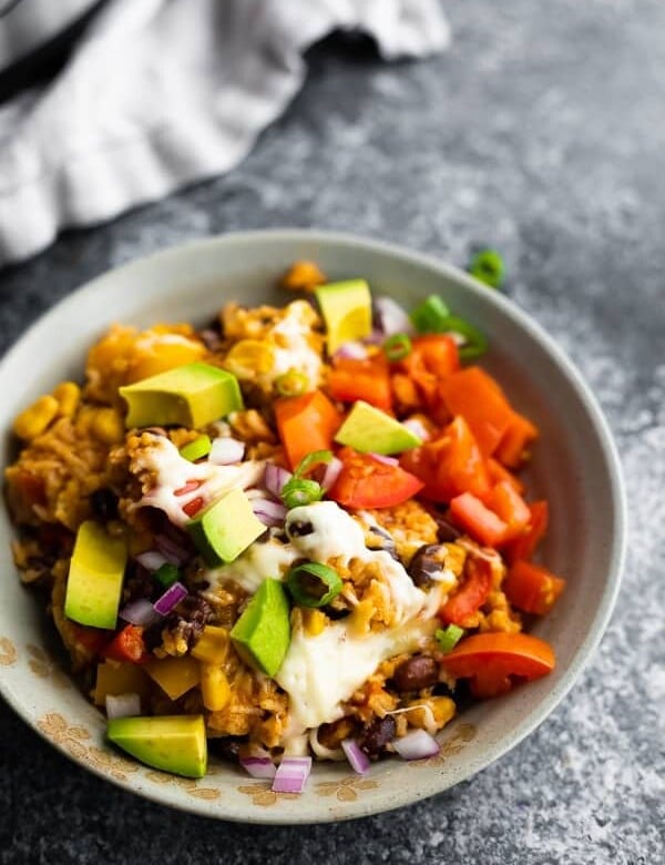 instant pot fiesta rice bowl in a gray bowl with avocado chunks and sliced green onion