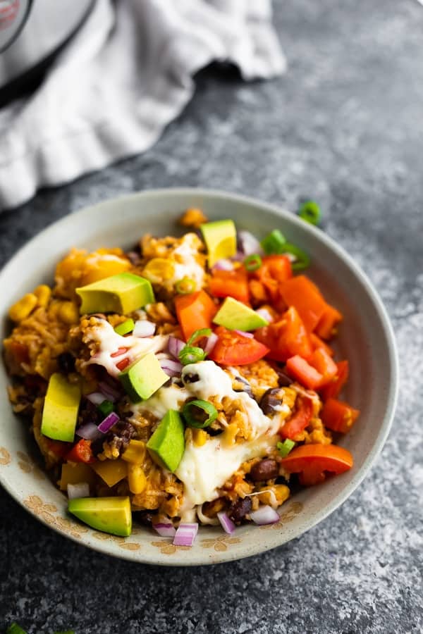 instant pot fiesta rice bowl in a gray bowl with avocado chunks and sliced green onion