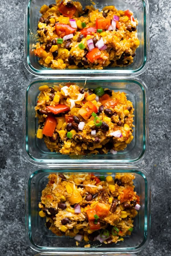 overhead view of the Instant Pot Fiesta Rice Bowls in three meal prep containers on grey background