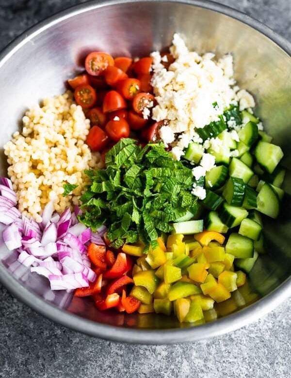Large mixing bowl with all the ingredients for summer couscous salad