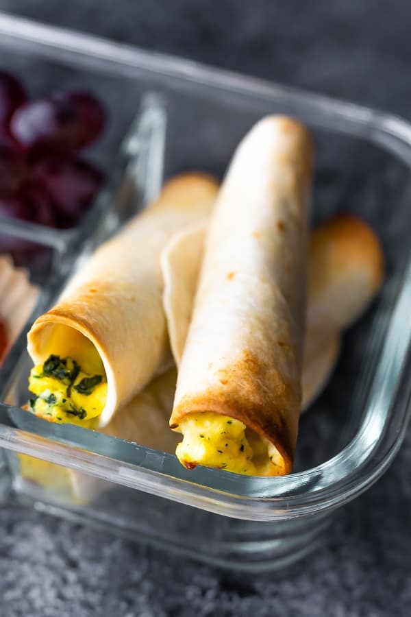 close up of breakfast taquitos in meal prep container