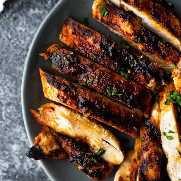 overhead shot of sliced grilled chicken breast on gray plate