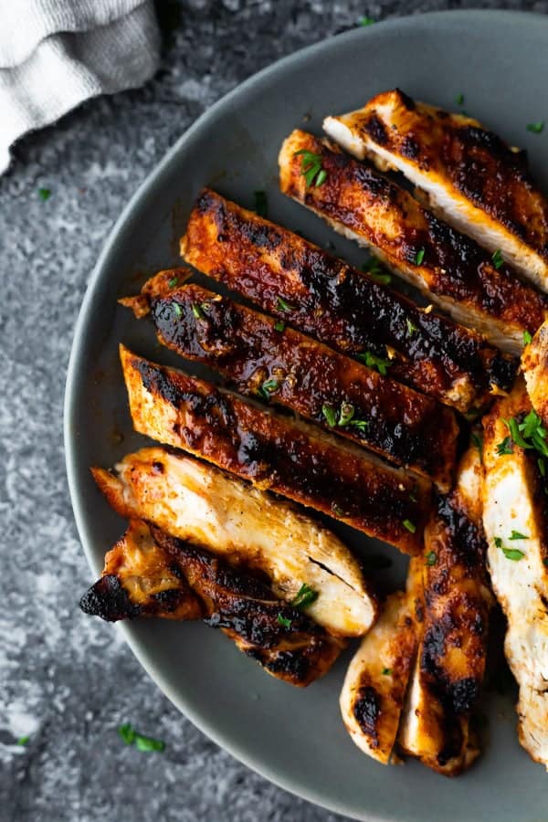 overhead shot of sliced grilled chicken breast on gray plate