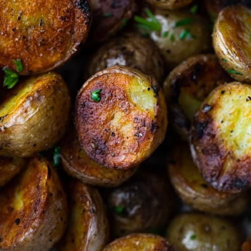 Close up shot of crispy grilled potatoes with parsley sprinkled on them