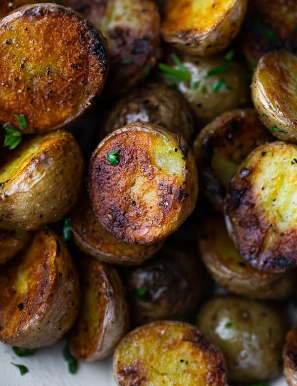 Close up shot of crispy grilled potatoes with parsley sprinkled on them