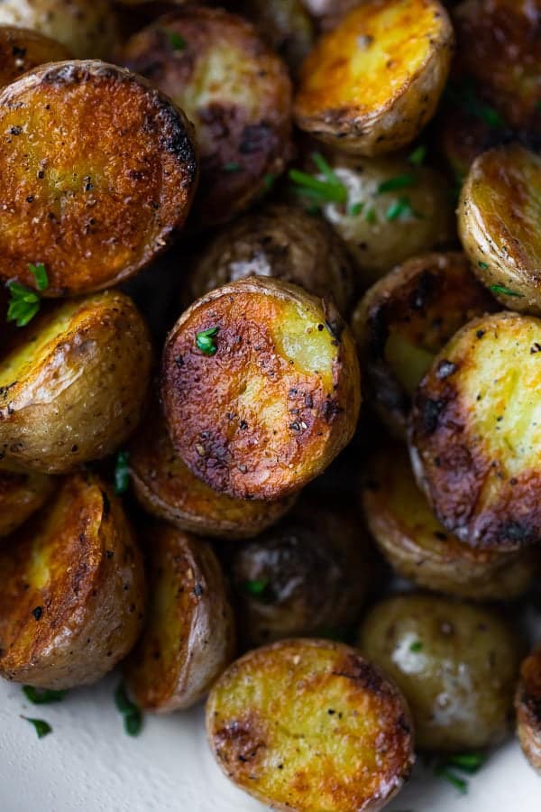 Close up shot of crispy grilled potatoes with parsley sprinkled on them