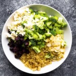 overhead shot of broccoli quinoa salad with almonds in white bowl