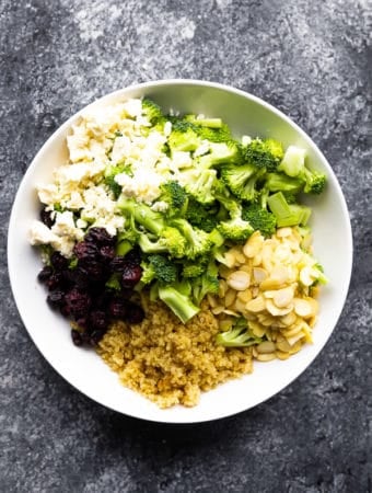 overhead shot of broccoli quinoa salad with almonds in white bowl