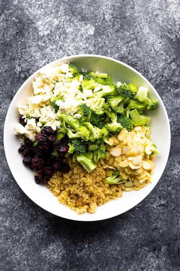 overhead shot of broccoli quinoa salad with almonds in white bowl