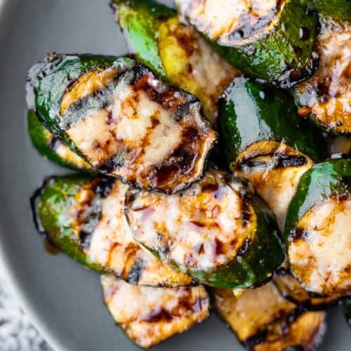 balsamic grilled zucchini with parmesan in a pile on gray plate