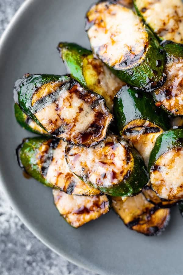 balsamic grilled zucchini with parmesan in a pile on gray plate