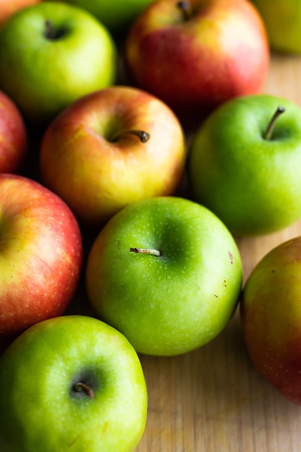 a variety of apples on cutting board 