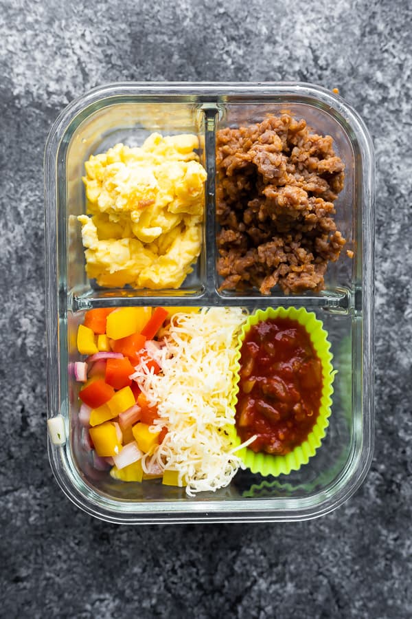 overhead view of breakfast tacos ingredients in meal prep container