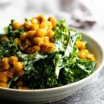 side view of kale caesar salad with garlic chickpeas in gray bowl