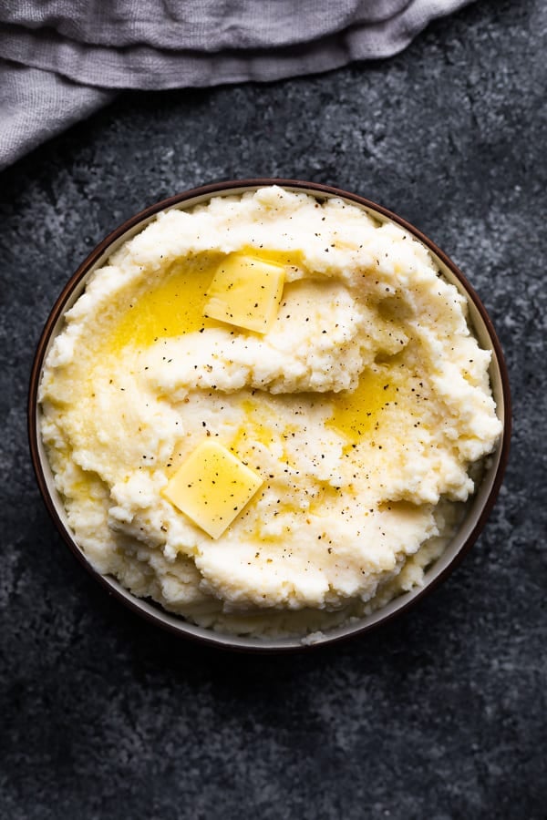 overhead view of mashed cauliflower recipe in bowl with melting butter