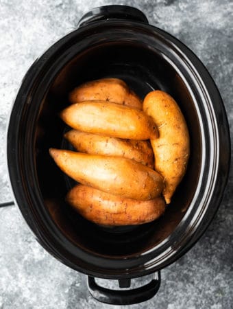 overhead shot of whole sweet potatoes in crock pot