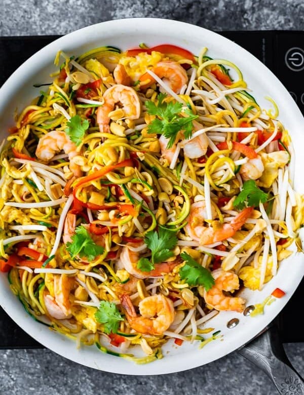overhead shot of zucchini noodle pad thai in large white bowl