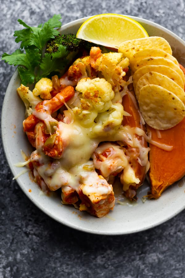 overhead shot of cheesy chicken on plate with tortilla chips and sweet potato