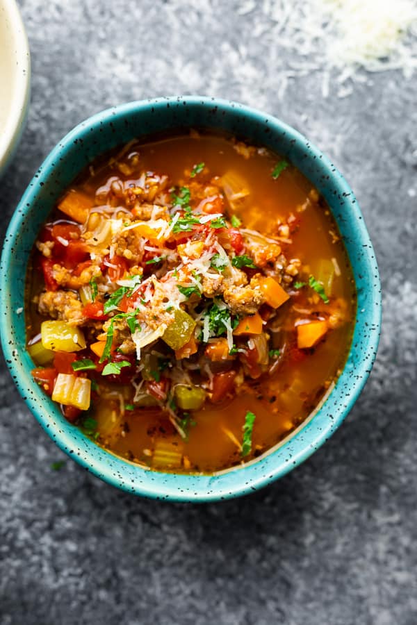 overhead view of sausage soup in blue bowl