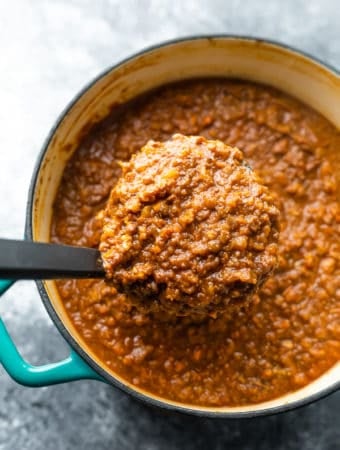 overhead shot of vegan bolognese in large le creuset pot with ladle