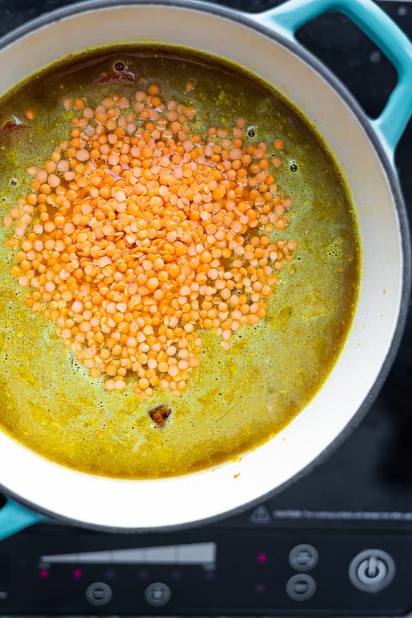 overhead view of red lentil dal in pot before simmering