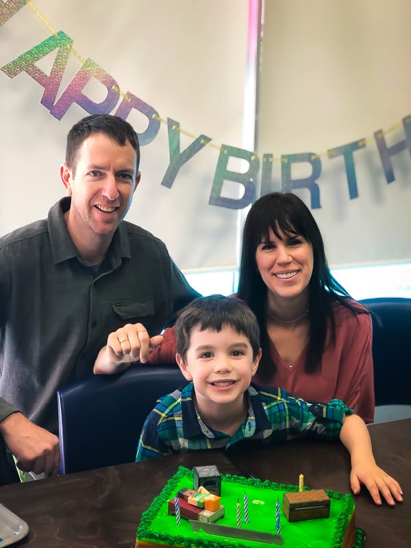 picture of Denise with her family and a happy birthday sign hanging up