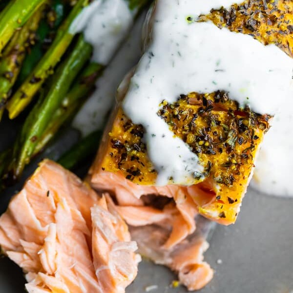 close up shot of baked lemon pepper salmon with asparagus on the side