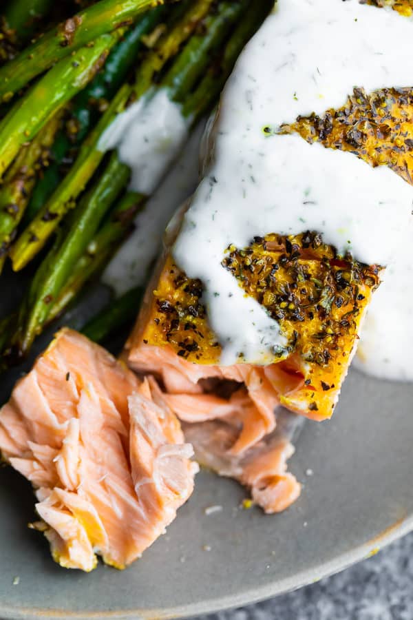 close up shot of baked lemon pepper salmon with asparagus on the side