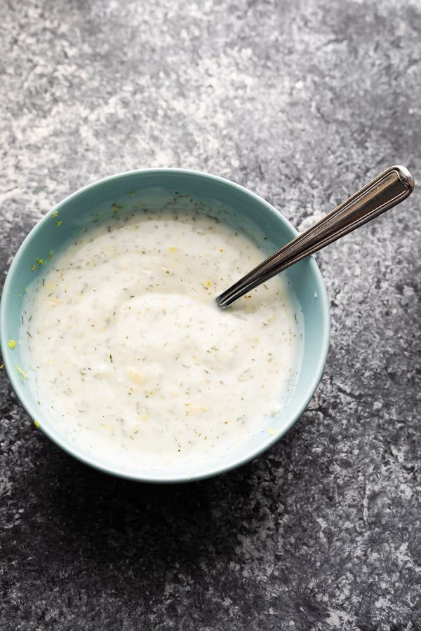 yogurt sauce in blue bowl for the baked lemon pepper salmon